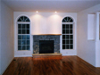 All stone fireplace surround with raised hearth looks beautiful between the specialty circle top windows